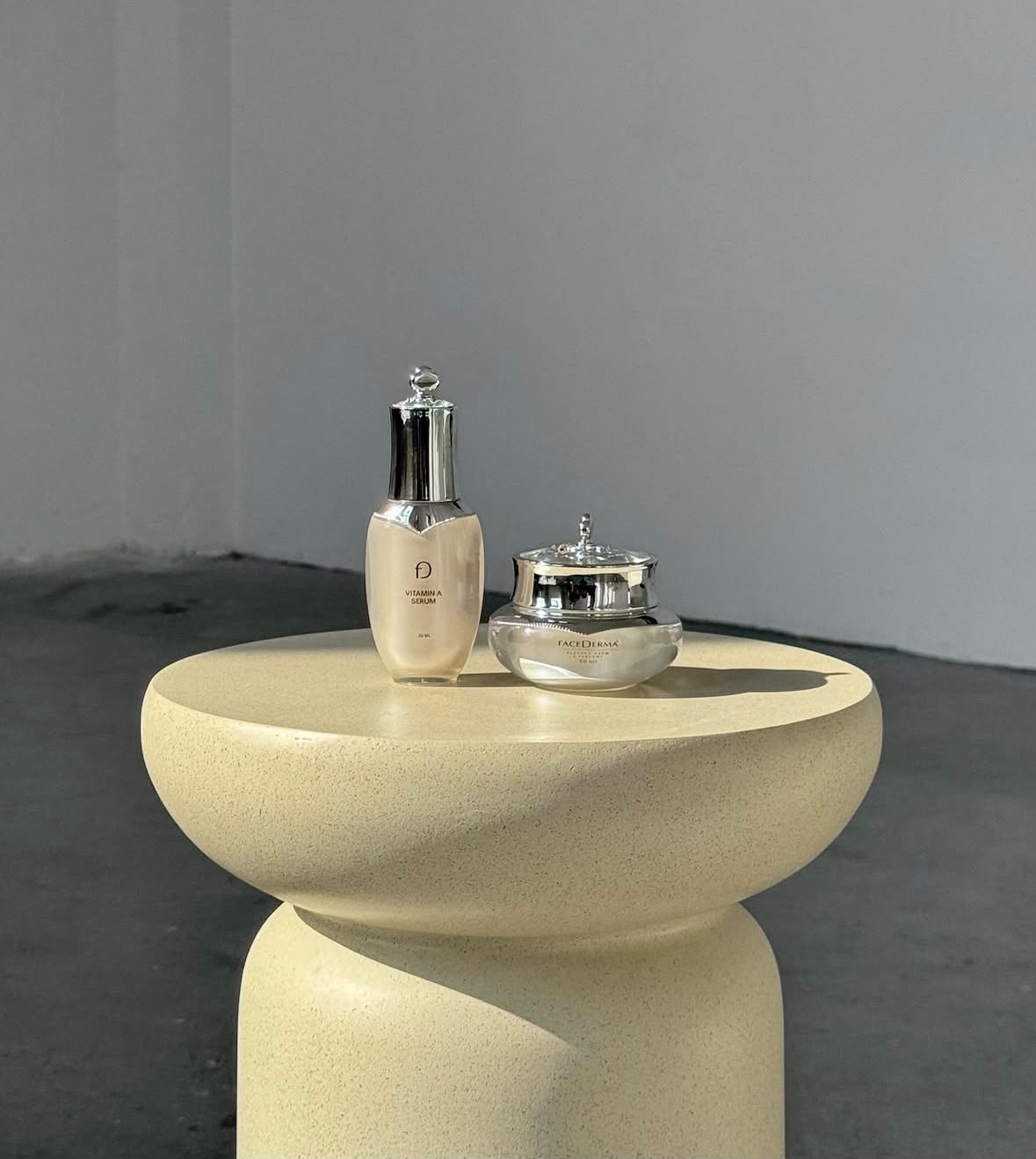 Facederma vitamin A serum and cream on a sculptural pedestal